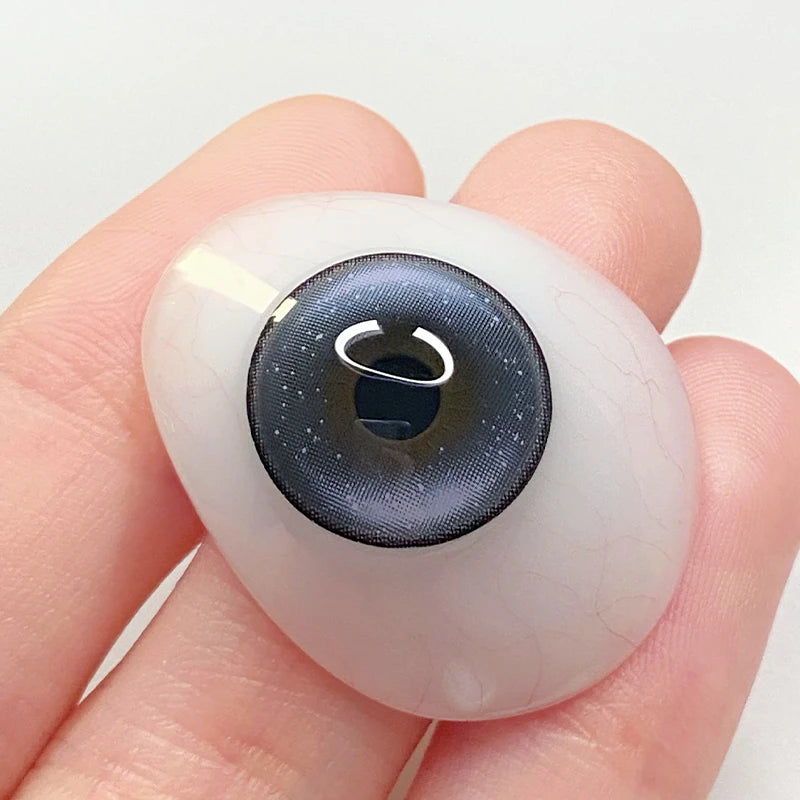 Inspecting the artistic gray pigment and reflective double highlights on a fingertip to show the quality of these colored contacts.