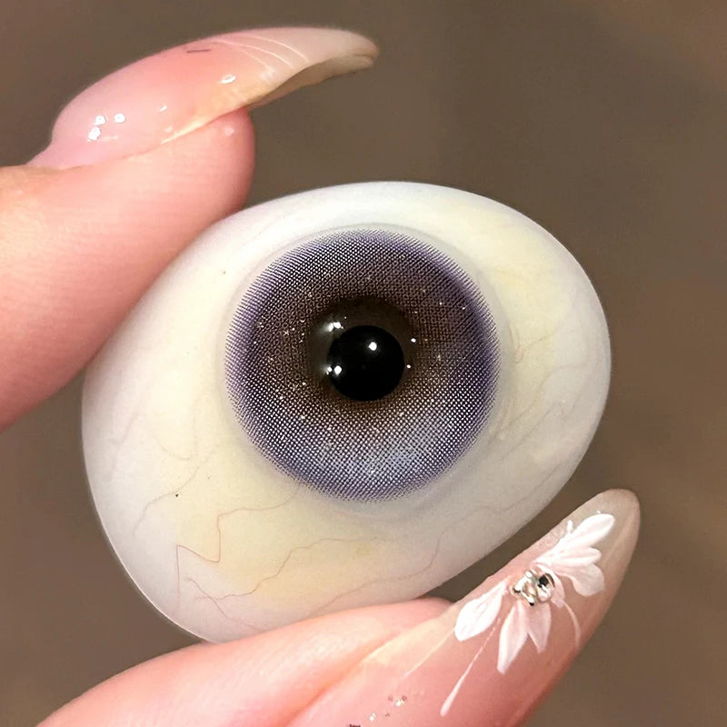 Witnessing the delicate, translucent lilac tint on a fingertip, highlighting the premium soft material of these lenses.