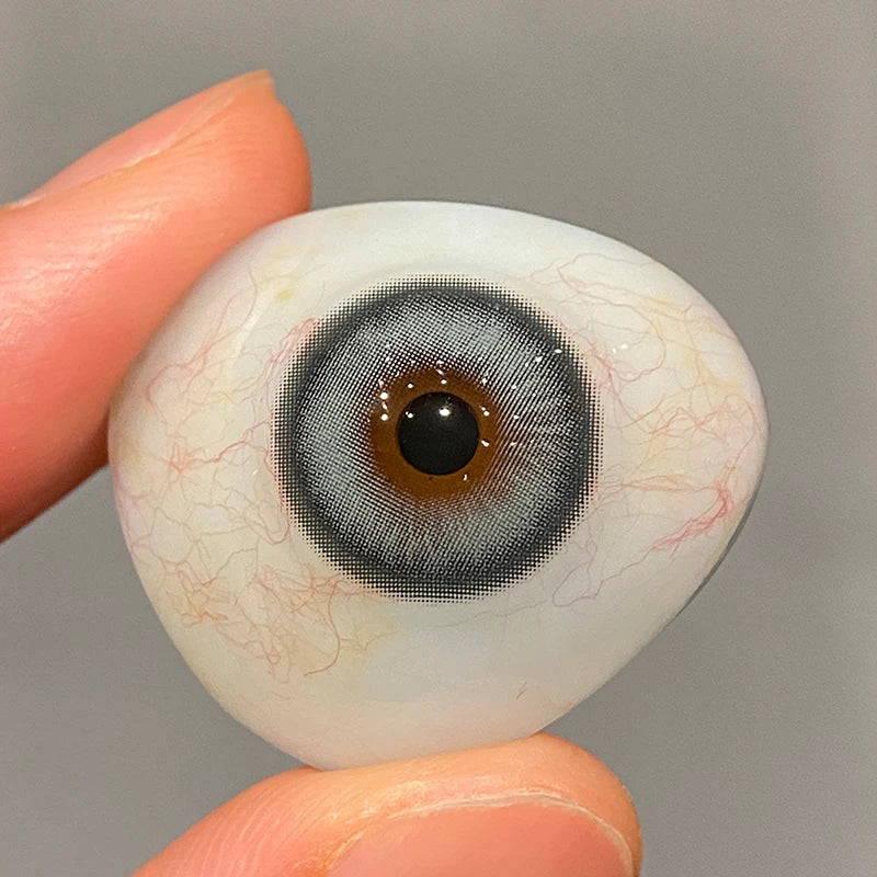 Real-life view of this delicate green tint on a fingertip, highlighting the soft material and authentic lens quality.