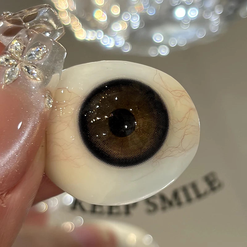 Capturing the authentic, sheer warmth of these brown colored contacts on a fingertip to show the premium quality.