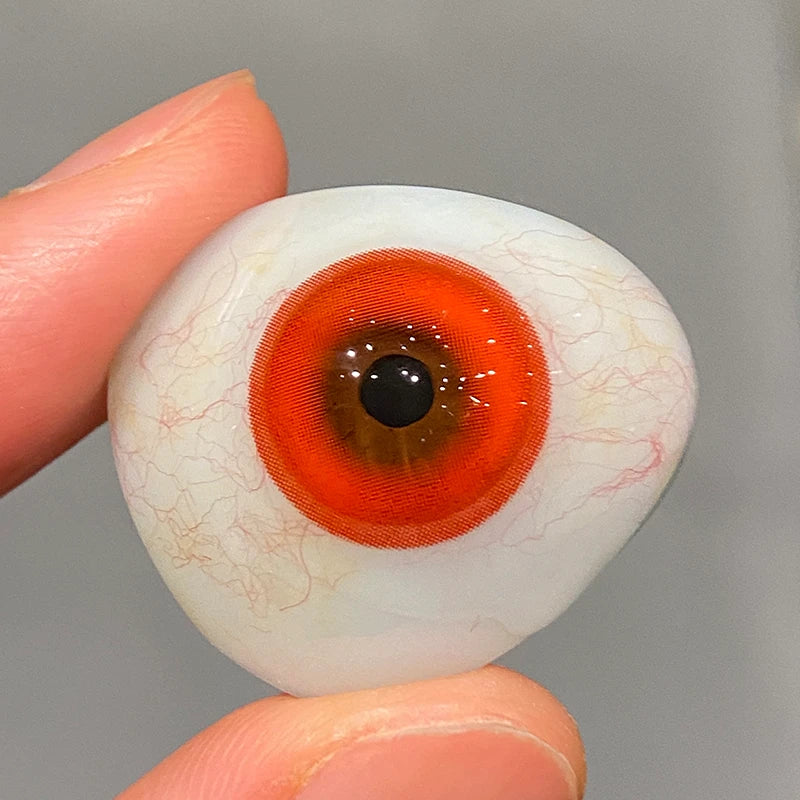 Observing the intense, pure red tint on a fingertip to confirm its superior, high-saturation quality.