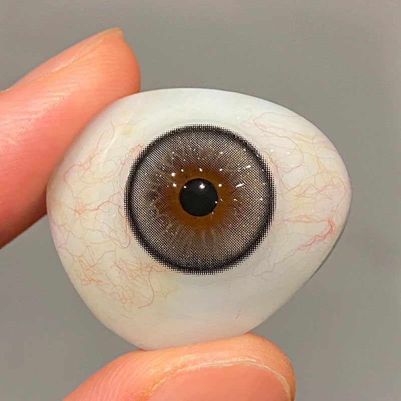 Observing the supple texture and rich tint on a fingertip, ensuring the premium quality of these colored contacts.